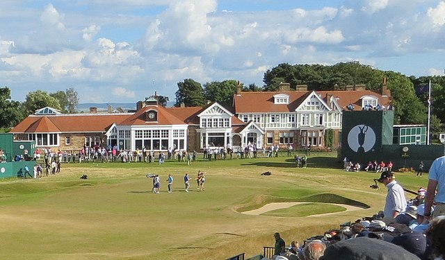 A Crowd Of People Watching A Golf Match.