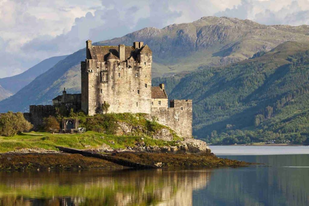 A Castle Sits On A Small Island In Scotland.